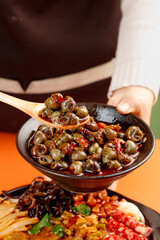 Spicy Braised Snails in Clay Bowl - Traditional Asian Stir-Fry Cuisine