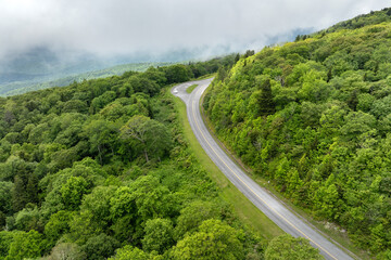 Winding mountain road in summer woods. Overlook point in Appalachian mountains in North Carolina with fresh green forest trees in summertime season. Beauty of USA nature