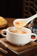 Hot Dumpling Soup Being Served with Spoon on Wooden Table - Traditional Asian Comfort Food