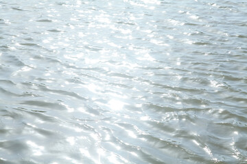 Clear Water Surface with Sunlight Reflections and Gentle Ripples - Natural Water Background Texture