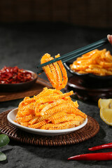 Spicy Golden Crispy Snack Strips with Chopsticks and Chili Sauce on Dark Background