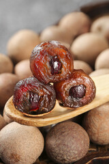 Dried dates and mixed nuts on wooden spoon - healthy organic food ingredients on white background