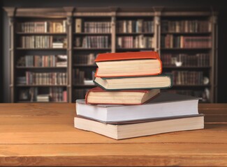 stack of books in library on wooden table