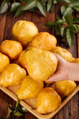 Fresh Golden Pears in Wooden Bowl with Hand Holding Fruit on Rustic Wood Table
