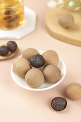 Dried Longan Gui Yuan Fruit from Guangdong China on White Background with Traditional Tea Setting
