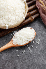 Fragrant White Jasmine Rice in Traditional Bamboo Basket with Wooden Spoon on Stone Surface