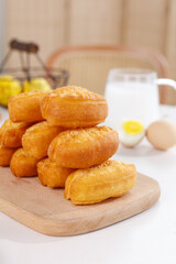 Fresh Homemade Golden Doughnuts Stack on Wooden Board with Milk and Eggs Traditional Breakfast Snacks