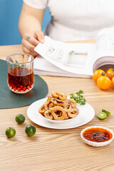 Spicy squid rings with chili sauce and lime on wooden table - delicious seafood appetizer ready to eat