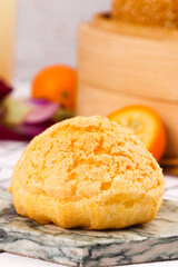 Fresh puff pastry dessert balls with citrus fruits on marble kitchen counter