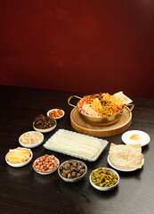 Asian Cooking Ingredients Collection with Vermicelli Noodles and Spiral Pasta on Dark Wood Surface