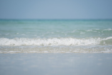 Serene View of Gentle Waves Lapping at Shoreline Under Clear Blue Sky on Tranquil Beach During Warm Sunny Day Ideal for Relaxation and Calmness