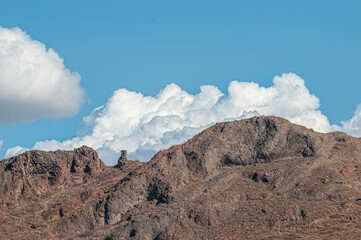 Rock formations on the mountain overlooking El Tecolote Beach with beautiful clouds in the blue sky on a summer afternoon, a scenic landscape of La Paz, Baja California Sur. Mexi