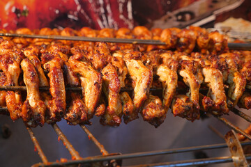Chicken skewers grilling at a vibrant street market