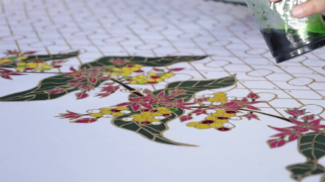 Close up of a flower being coloured on pattern traditional batik from indonesia . 4k batik. 4k art

