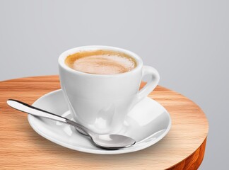 A ceramic cup with aroma coffee on a wooden table