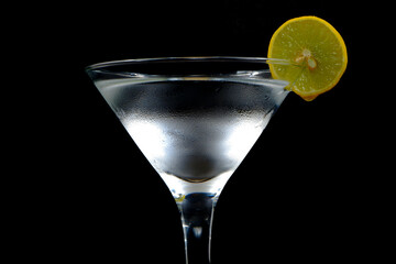 A glass of Ice water with lemon closeup shot on black background 