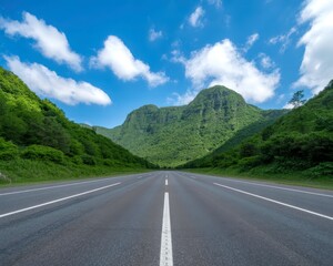 Fototapeta premium Scenic road view leading to lush green mountain under blue sky with white clouds in tropical landscape