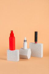 Cosmetic pink bottle. Womens cosmetic accessory for makeup with stylish props on cream background.