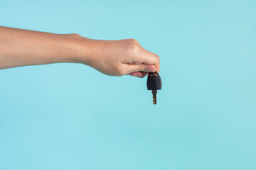 Black locker key in hand on blue background