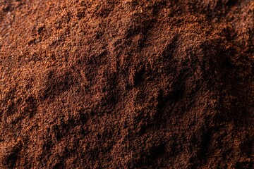 Close up view of finely ground roasted coffee powder creating an earthy brown textured heap, ready for brewing