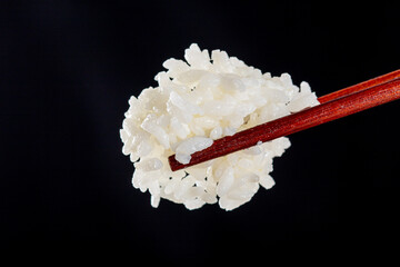 Chopsticks Lifting Rice On Black Background