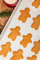 A batch of freshly baked gingerbread man cookies on a baking tray.