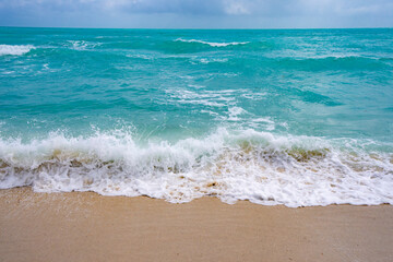Sea background. Blue ocean. Sandy ocean beach. Ocean waves. Summer seaside. Tropical ocean coastline. Exotic turquoise water. Foamy wave splash on sea. Sunny beach view.