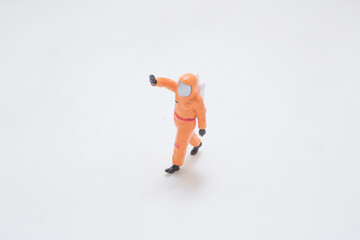 A Tiny Orange Astronaut Figure Walking Across
