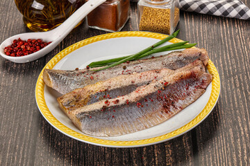 Salted marinated herring fillet with spices
