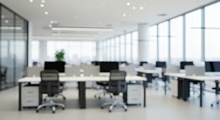 Modern blurred office interior with desks, chairs, and computers. Bright daylight through large glass windows creates a clean, minimal, and professional work environment with a soft focus aesthetic.