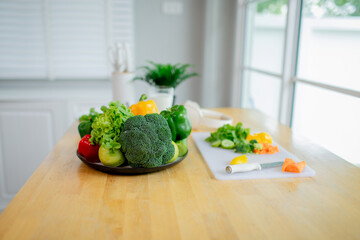 Woman holding fresh salad bowl with vegetables, promoting healthy eating, organic lifestyle, and balanced diet in a colorful kitchen setting.
