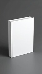 A plain white, square book stands upright on a smooth, grey surface with soft lighting. The binding is visible