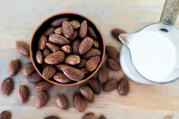 Vegan almond milk, almond kernels and whole almonds on the wooden table. Top view