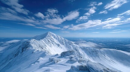 Obraz premium Snowy Mountain Peak Under a Vivid Blue Sky with Scattered Clouds on a Bright Day Mountain Landscape with White and Blue Colors on Winter Season