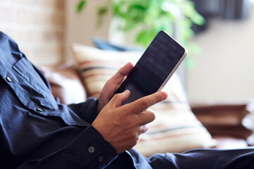タブレット端末を操作する日本人シニア男性の手元