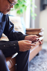 タブレット端末を操作する日本人シニア男性の手元