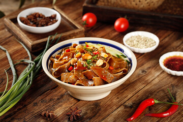 Shaanxi Buckwheat Noodles with Red Oil Sauce - Traditional Chinese Cuisine on Wooden Table
