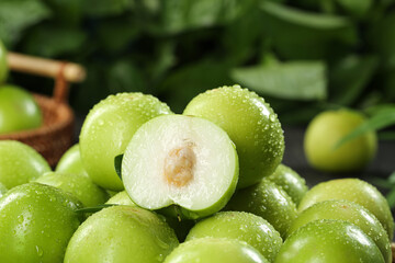 Fresh Green Plums with Water Droplets - Half Cut Showing Pit and Seeds