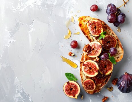 Two fig & grape toasts drizzled with honey, on a textured grey surface with mint, for a fresh, colorful, and inviting food presentation