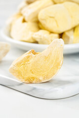 Golden Freeze Dried Durian Fruit Slices in Bowl on Marble Surface