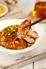 Spicy Sichuan Sausage with Green Onions - Traditional Chinese Specialty Dish with Chopsticks