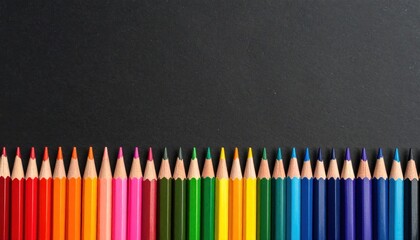 Colorful pencils arranged in a horizontal row on a dark background