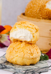 Fresh Cream Puff Pastry Dessert with White Filling on Marble Surface