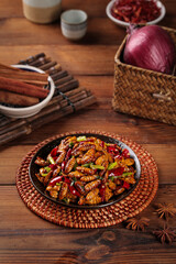 Fototapeta premium Crispy Golden Silkworm Pupa Stir-Fry Traditional Shandong Chinese Dish with Red Peppers and Spices on Wooden Table