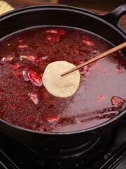 Handmade Tofu Roll Cooking in Spicy Red Broth with Five Spice Seasoning - Traditional Asian Vegetarian Cuisine