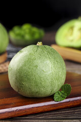Fresh Green Melons from Shandong China on Wooden Cutting Board with Mint Leaves