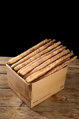 Fresh Chinese Yam Roots from Henan Province Farm in Cardboard Box on Wooden Table