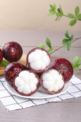 Fresh Mangosteen Fruit from Thailand - Purple Tropical Fruit with White Flesh Segments on Plate