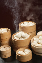 Traditional Chinese Xiao Long Bao Soup Dumplings and Steamed Buns in Bamboo Steamers with Hot Steam