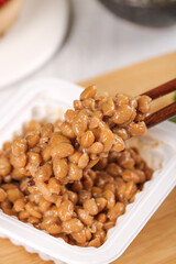Traditional Japanese Natto Fermented Soybeans with Wooden Chopsticks in White Dish